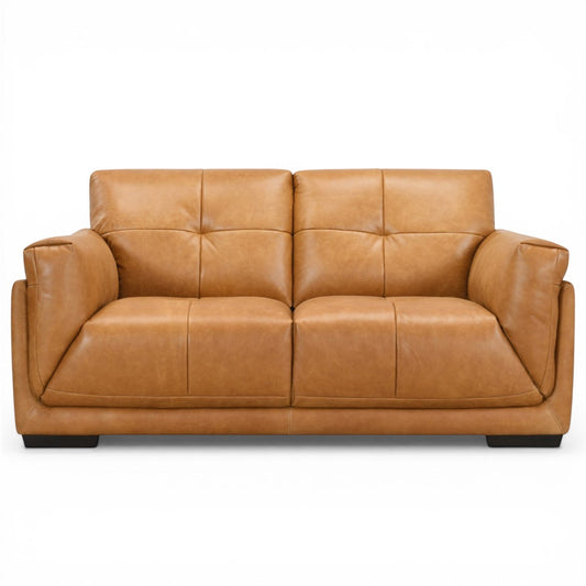 Pieces For Places Theo tan leather 2-seater sofa with tufted back cushions and low-profile dark wood feet.