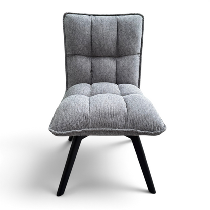 Pieces For Places Bubble grey fabric swivel dining chair with a tufted seat and black metal legs in a warehouse setting.