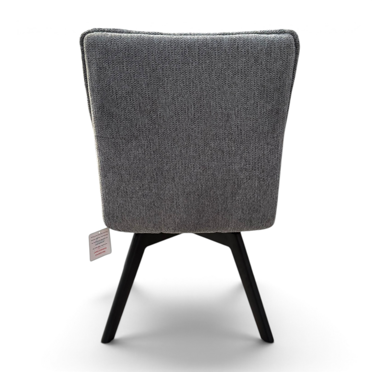 Pieces For Places Bubble grey fabric swivel dining chair with black metal legs viewed from the back in a warehouse.