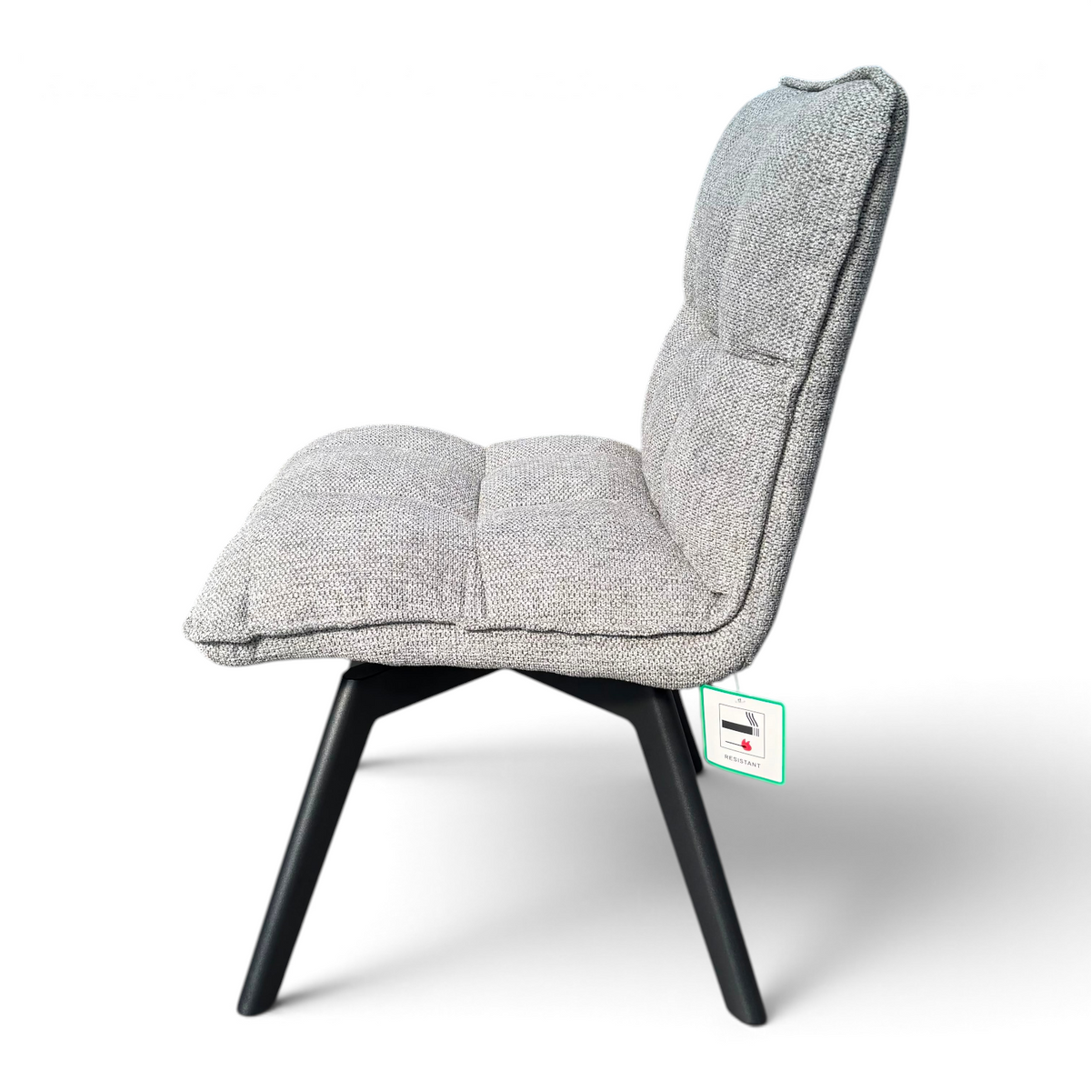 Pieces For Places Bubble grey fabric swivel dining chair with black metal legs and stitched back detail, side view.