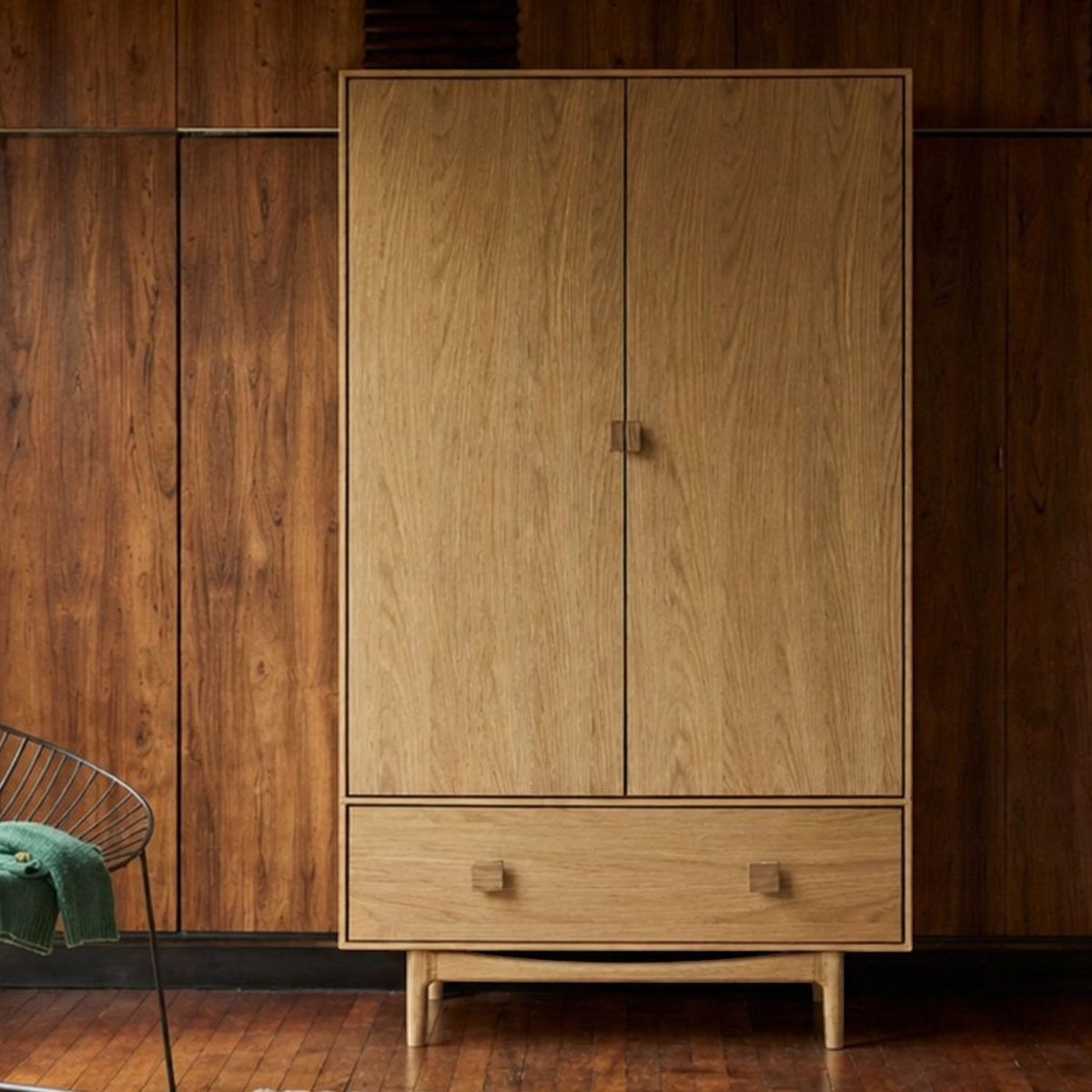 Pieces For Places Larsen double wardrobe in natural wood with tapered legs and a lower drawer in a mid-century room.