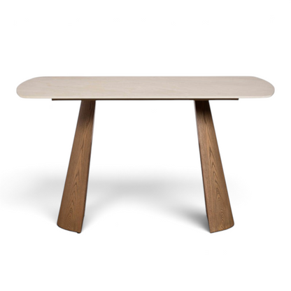 Pieces For Places Lusso 135cm dining table with a light sintered stone top and angled ash veneered wooden legs.
