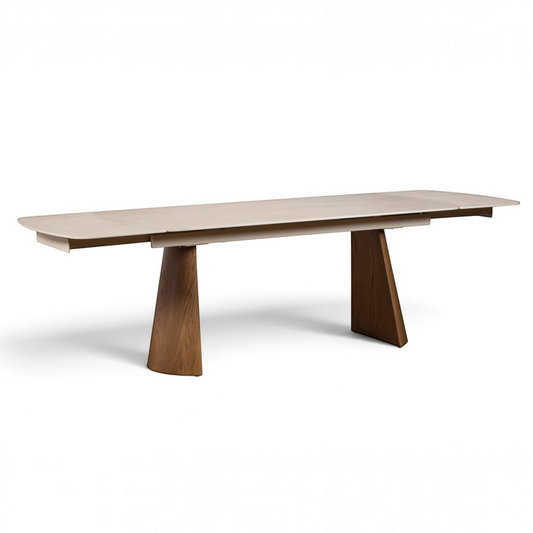 Pieces For Places Lusso extending dining table with a sintered stone top and ash-veneered pedestal legs.