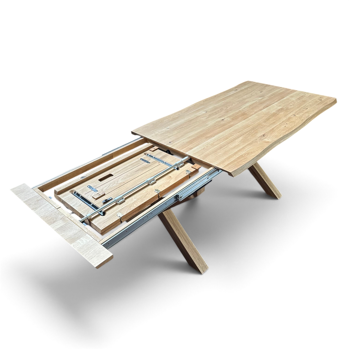 Pieces For Places oiled oak extending dining table with natural live edge and X-shaped legs showing internal mechanism