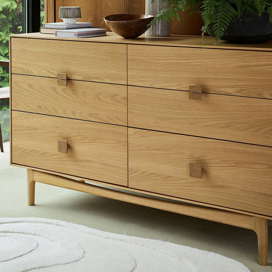 Pieces For Places Larsen 6 drawer wide chest in light oak wood with minimalist square handles and tapered legs.