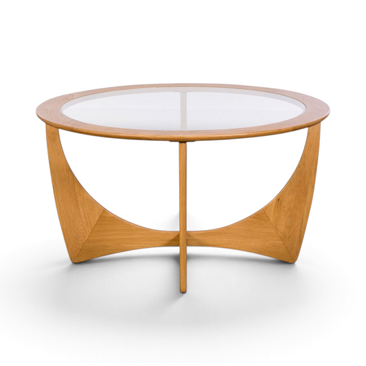 Pieces For Places Larsen round coffee table with a glass top and sculptural light oak wood base in mid-century style.