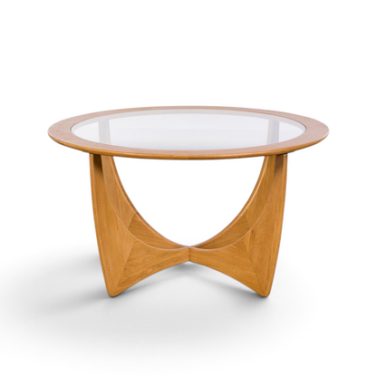 Pieces For Places Larsen round coffee table with a glass top and sculptural light wood base in mid-century style.