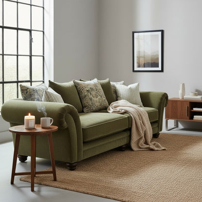 Pieces For Places Hampshire Extra Large Split Pillow Back Sofa in olive green fabric with scroll arms and wooden feet. A woman reads on the sofa.