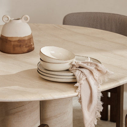 Pieces For Places Ida 120cm round dining table with travertine finish, column legs, and minimalist table setting.