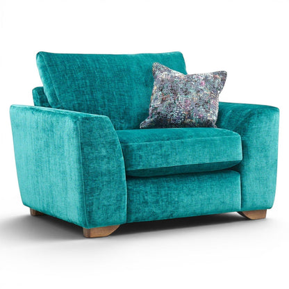 Pieces For Places Milo Armchair in teal velvet with a patterned scatter cushion and wooden feet. Modern design for plush comfort.