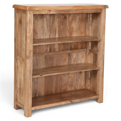 Pieces For Places Olda small bookcase made of natural mango wood with three open shelves and visible wood grain.