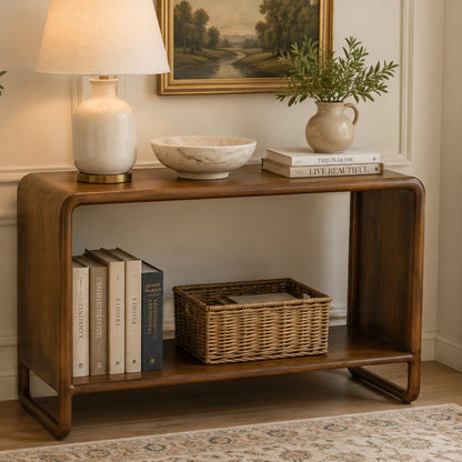 Pieces For Places Saturn curved console table in solid mango wood with a natural finish and open lower shelf.