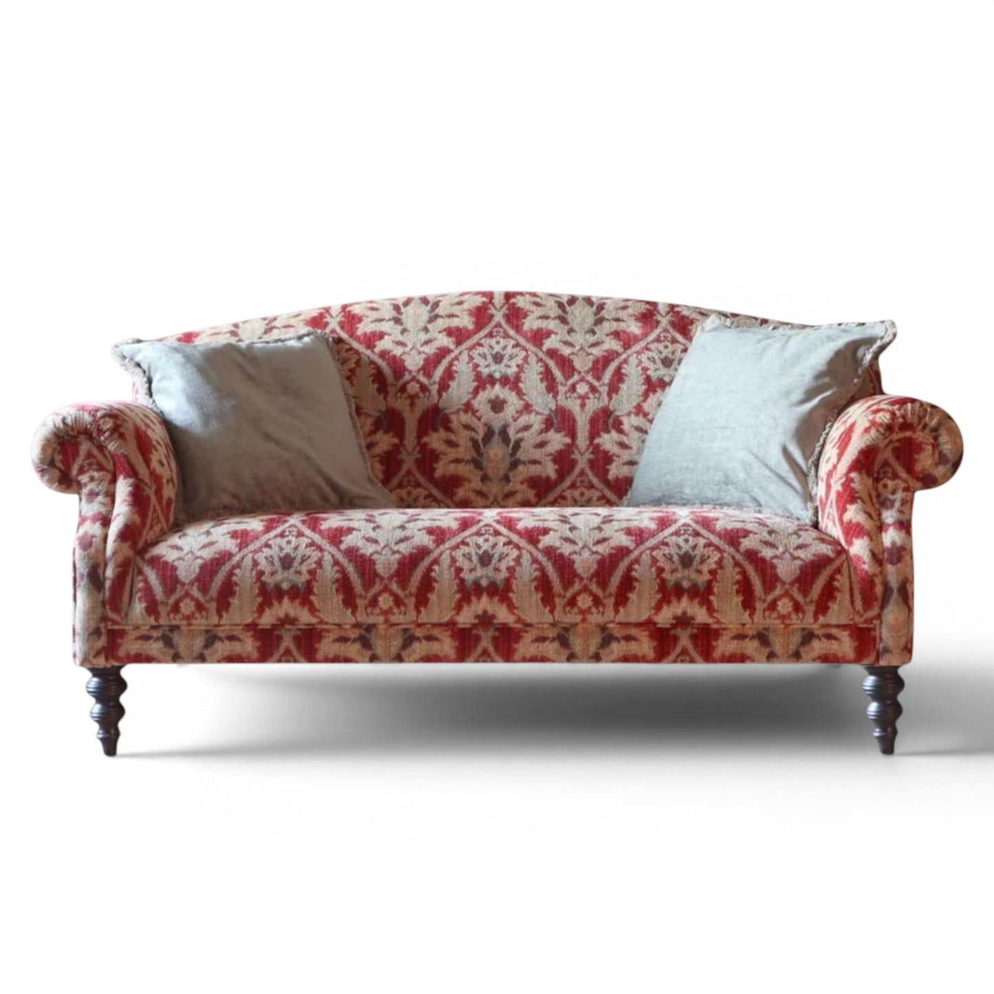 Pieces For Places Tallis Petit Sofa in red damask fabric with rolled arms and two light grey scatter cushions on dark wood legs.