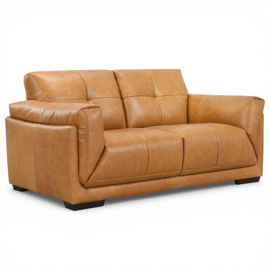 Pieces For Places Theo tan leather 2-seater sofa with tufted back cushions and low-profile dark wood feet.