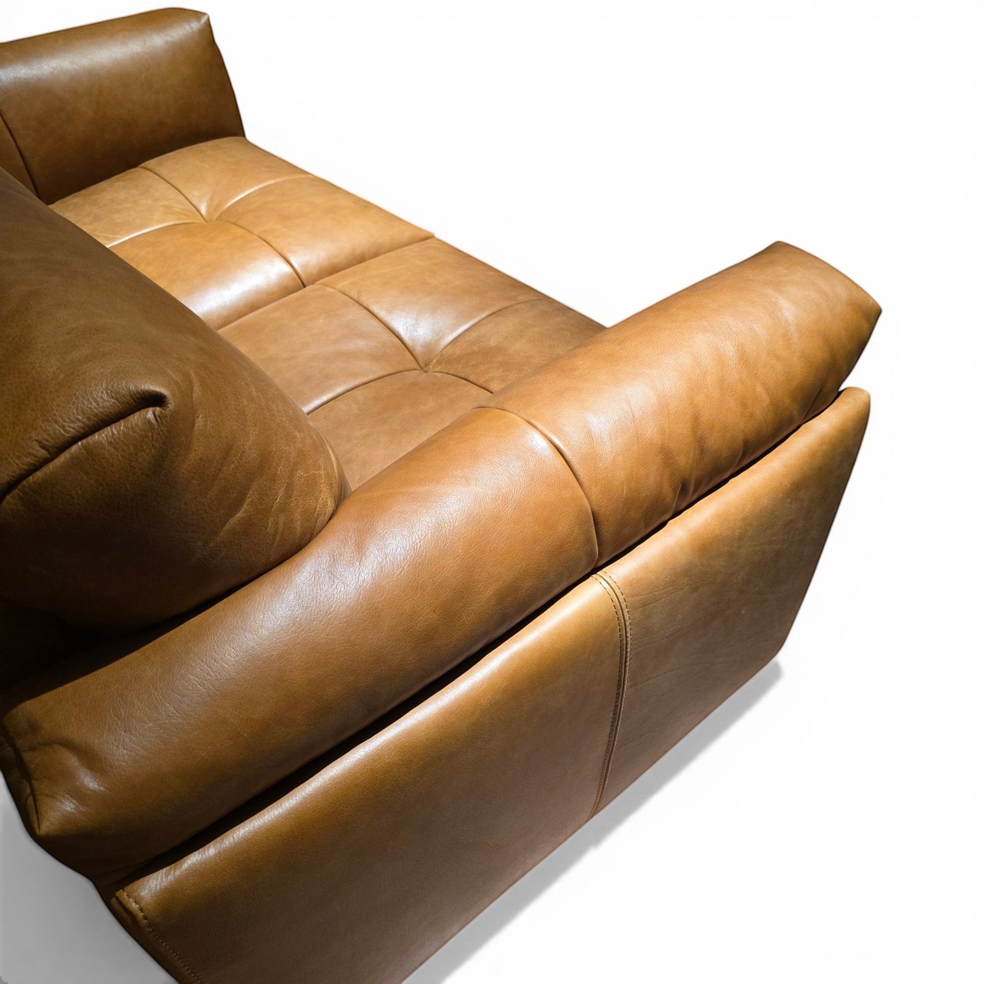 Pieces For Places Theo tan leather 2-seater sofa with tufted seat cushions and bolster armrest. Natural uncoated leather develops a patina over time.