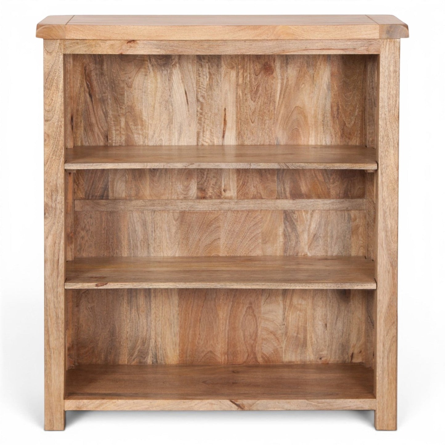 Pieces For Places Olda small bookcase made of natural mango wood with three open shelves. Visible wood grain and tonal variations.